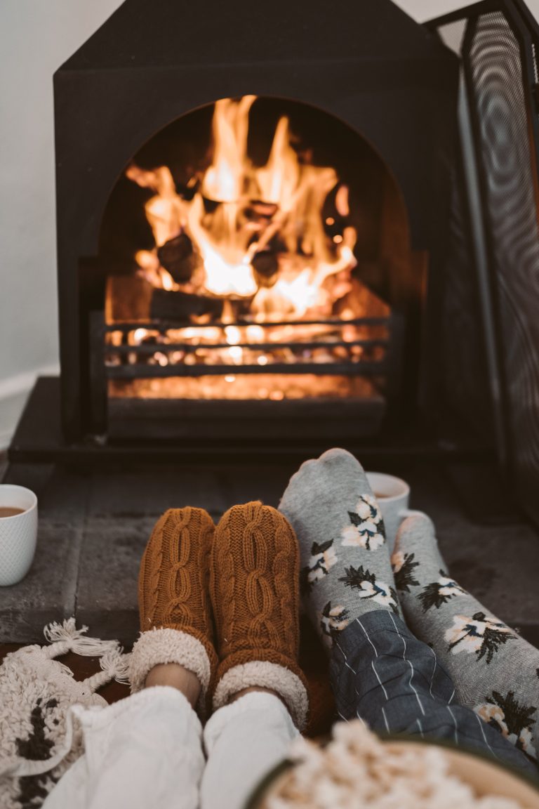 Fireplace in a cozy home, with two sets of wool stocking feet in front